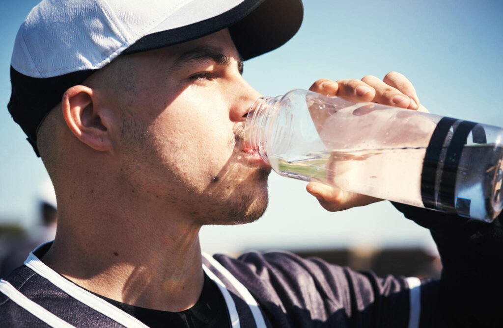 softball player driking from a water bottle