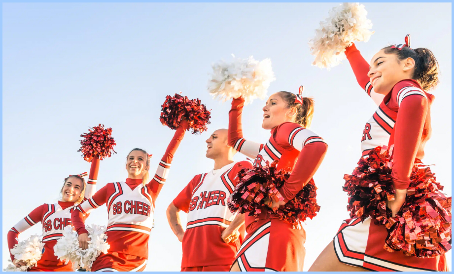 Cheerleaders, clad in vibrant uniforms, execute synchronized jumps and flips, radiating energy and spirit.